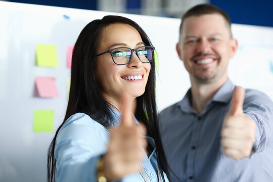 Man And Woman Show Ok Gesture In Office. Colleagues Rejoice At Successful Completion Of Work