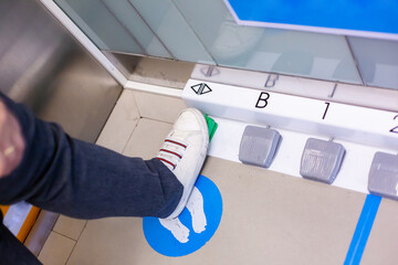 The foot is stepping on the foot switch to select the floor in the passenger lift. Modify the...