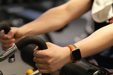 close up man's arm wearing smart watch, exercising on gym equipment. blur background