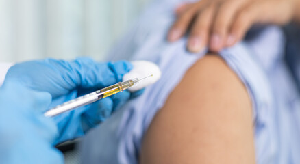 Doctor is vaccinating against Asian men in the hospital.