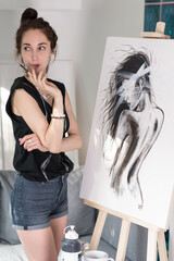 beautiful girl in hands paintbrush, happy looks model poser, draws silhouette of woman, painting...