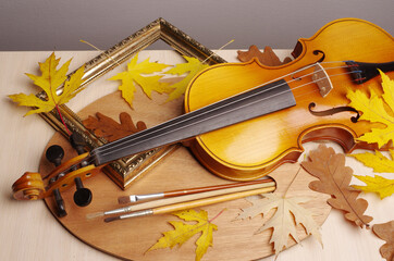 Fototapeta premium Violin, bow, art palette, brushes and autumn maple leaves.