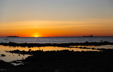 A bright sunset on a summer day on the shore of the Baltic Bay. Saint Petersburg, Russia.