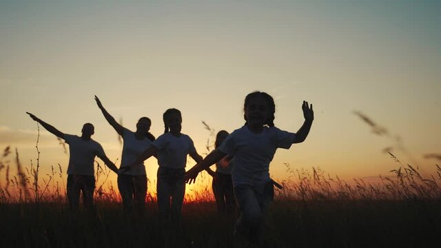 dream future concept. children kid run happy family concept at sunset silhouette. hands on hand play aviator pilot show airplane. people in the park parents mom and dad lifestyle children daughter