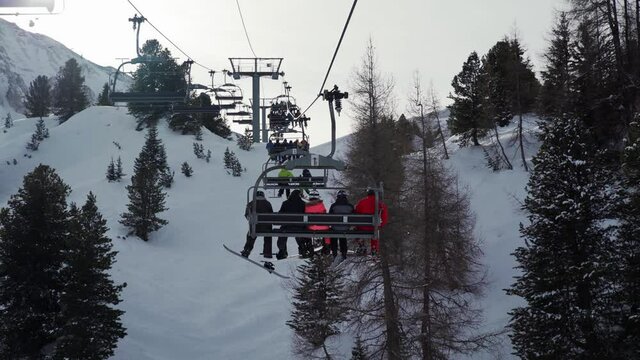 Snowboarder going up the ski lift at La Plagne ski resort, Tarentaise, Savoy, French Alps