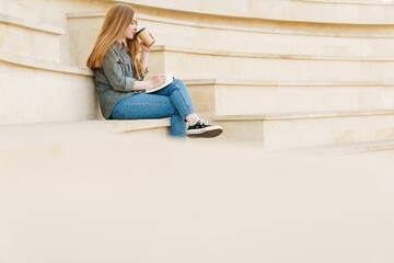 Attractive young girl writting in a notebook