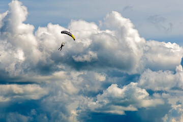 A skydiver athlete on the background of Cumulus clouds in the sky