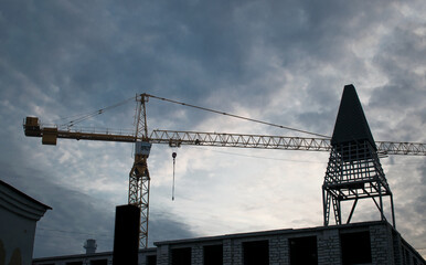 Construction site with yellow crane and dark blue sky