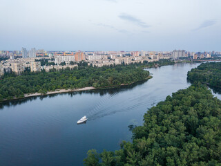 Fototapeta na wymiar Aerila drone view. The boat sails along the Dnieper River in Kiev. Evening.