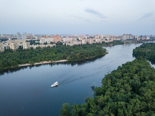 Aerila drone view. The boat sails along the Dnieper River in Kiev. Evening.