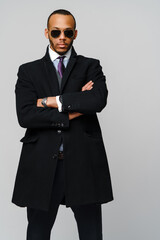 Obraz na płótnie Canvas studio shot of a african-american businessman wearing coat over light grey background