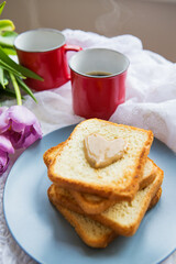 Homemade breakfast in bed. Toast with peanut butter, a cup of coffee and tulips. Good morning.