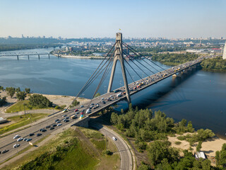 Aerial drone view. Cars travel along the North Bridge over the Dnieper River in Kiev. Summer sunny day.