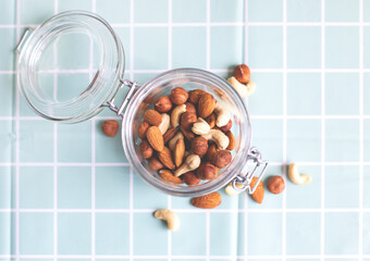 Mix of nuts in a glass jar. Cashews, hazelnuts and almonds. Selective focus, copy space. The concept of vegetarian and organic food.