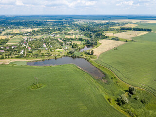 Fototapeta na wymiar Aerial drone view. A field of ripening wheat and corn in Ukraine near the lake.