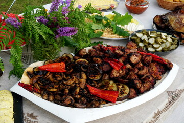 Traditional midsummer festive table with fried meat - shashlik, cheese, pies, fruit and other snacks, Latvia