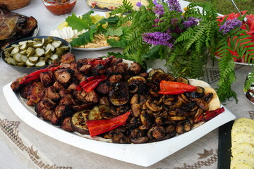 Traditional midsummer festive table with fried meat - shashlik, cheese, pies, fruit and other snacks, Latvia