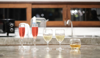 Close-up white wine glass and red wine glass and alcohol on cement table in resort restaurant