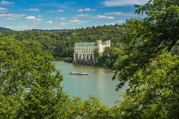 View of Orlik Castle, must see in the Czech Republic.Famous tourist place on a rock above Vltava river.Beautiful summer landscape with Orlík Water Reservoir and boats.Travel background space for text