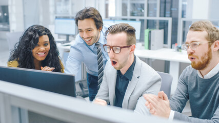 Obraz premium In Modern Office: Diverse Team of Young Motivated Businessmen and Businesswoman Work on Computer, Having Discussion, Finding Problem Solution Collectively, Surprised. Businesspeople Collaboration