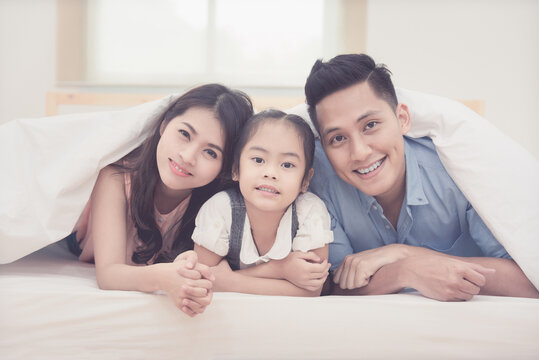 Asian family happy smiling and relax on bed at home. Photo series of family, kids and happy people concept.