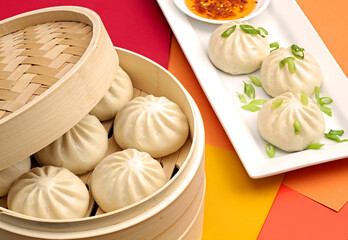 Chinese steamed buns filled with pork and seasoning in traditional bamboo steamer