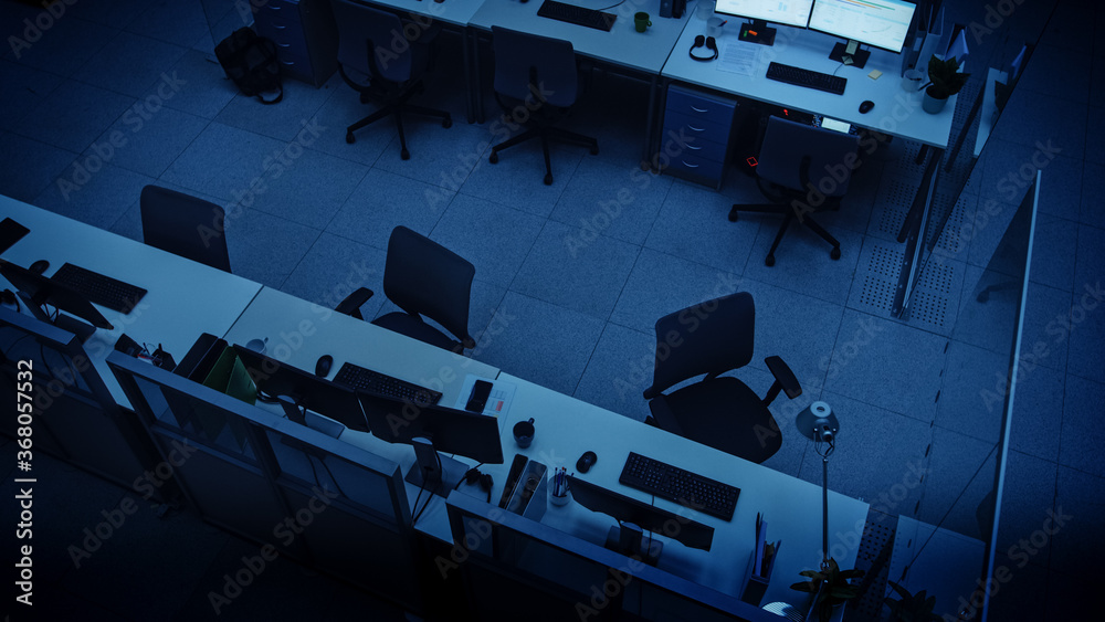 Poster elevated high angle shot of dark empty office with wheelchairs, desks and computers. concept of fini