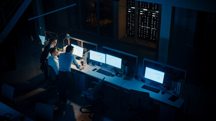 Late at Night In Modern Office: Diverse Team of Successful Businessmen and Businesswomen Gather Around Computer, Have Discussion, Find Problem Solution, Finishing Project Together. High Angle