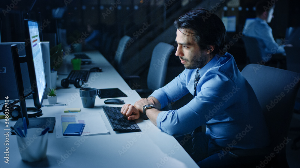 Aufkleber in the office at night overworked tired office worker uses desktop computer. tired exhausted busines