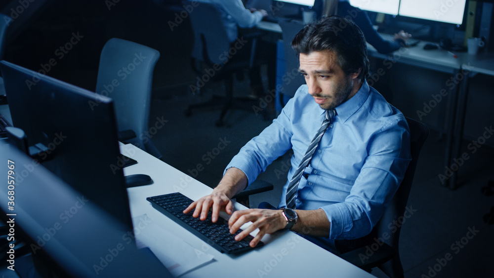 Poster in the office at night overworked tired office worker uses desktop computer yawning. tired exhausted