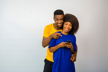 Fototapeta premium two young cute africans isolated over white background feeling overexcited about they saw on their cellphone