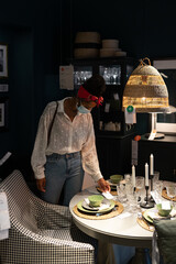 Unrecognizable black buyer selecting dishware in mall during coronavirus pandemic