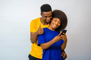 two young cute africans isolated over white background feeling overexcited about they saw on their cellphone