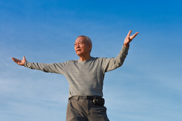 Asian Senior old man practice Taichi Chinese Kungfu on the beach
