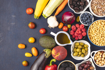 Top view of raw Mediterranean diet ingredients placed on dark background.