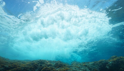 Underwater sea wave breaking on rock below water surface, Mediterranean sea