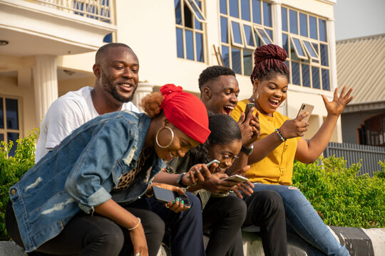 Group Of Excited Young Black People Using Their Phones