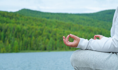 Yoga woman, meditation, yoga poses. Cropped close up of female in lotus position meditating in the mountains copy space happiness living vitality health balance recreation relaxation freedom nature
