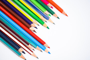 Few different colored wood pencil crayons scattered across a white background