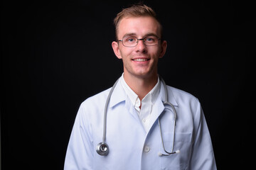 Portrait of young handsome man doctor with blond hair