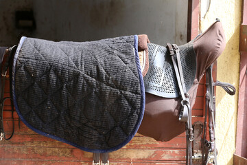Photo of old leather saddle with stirrups