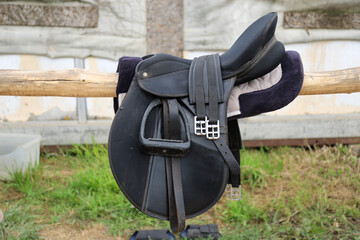 Photo of old leather saddle with stirrups