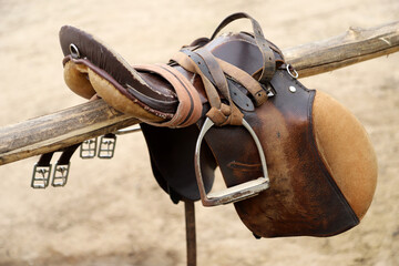 Photo of old leather saddle with stirrups