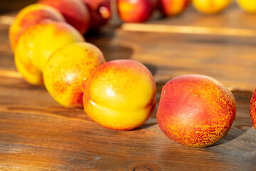 ripe juicy nectarines are laid out in a row on a wooden background. fruit harvest