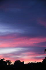 Colorful clouds and city silhouette at sunset