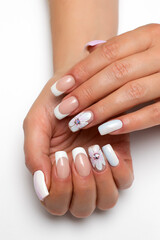 Wedding french white manicure with white painted flower on a white background close-up on long square nails. Gel design.