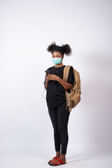 young black woman wearing a face mask using her mobile phone