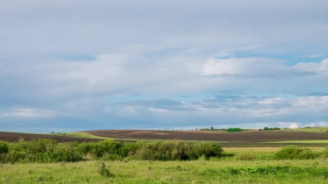 Timelapse of scenic landscape. Amazing clouds in the blue sky over the fields