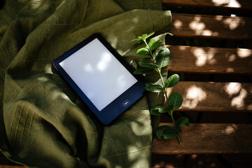 Ebook Reader on a wooden table with a green plant