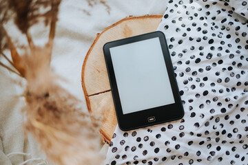 Ebook Reader on a wooden disc and black and white dotted fabric